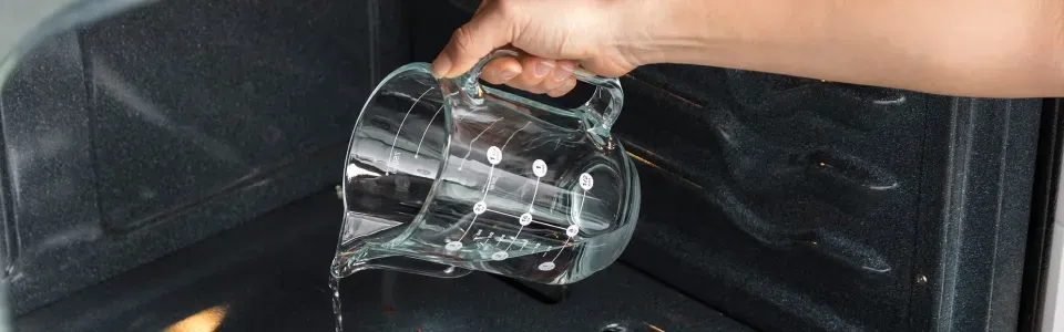 womans-hand-closeup-pouring-water-for-steam-cleaning